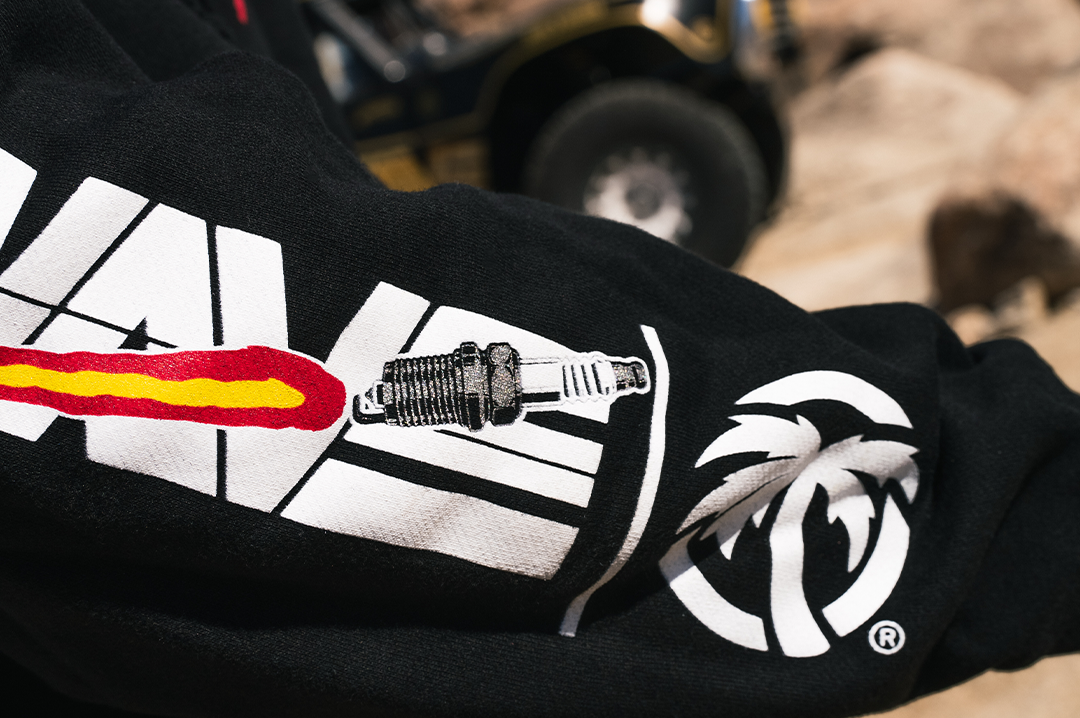 Close up of the arm of a black sweatshirt with Heat Wave spark racing graphics printed on it.