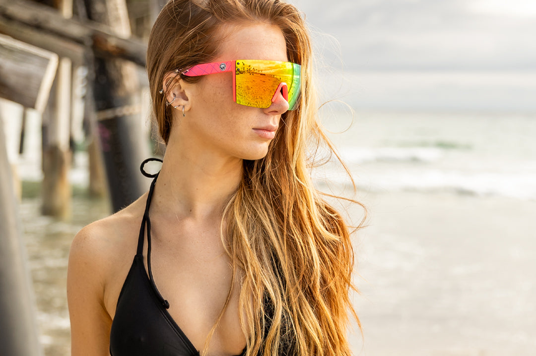 Young women at the beach wearing Heat Wave Visual Lazer Face Z87 Sunglasses with pink frame, standup print arms and spectrum pink yellow lens. 