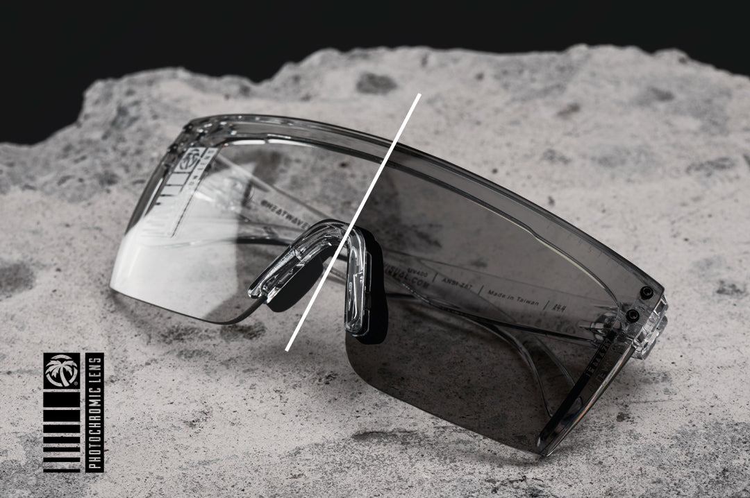 Laying on some concrete is the Heat Wave Visual Lazer Face Sunglasses with clear frame and photochromic lens.