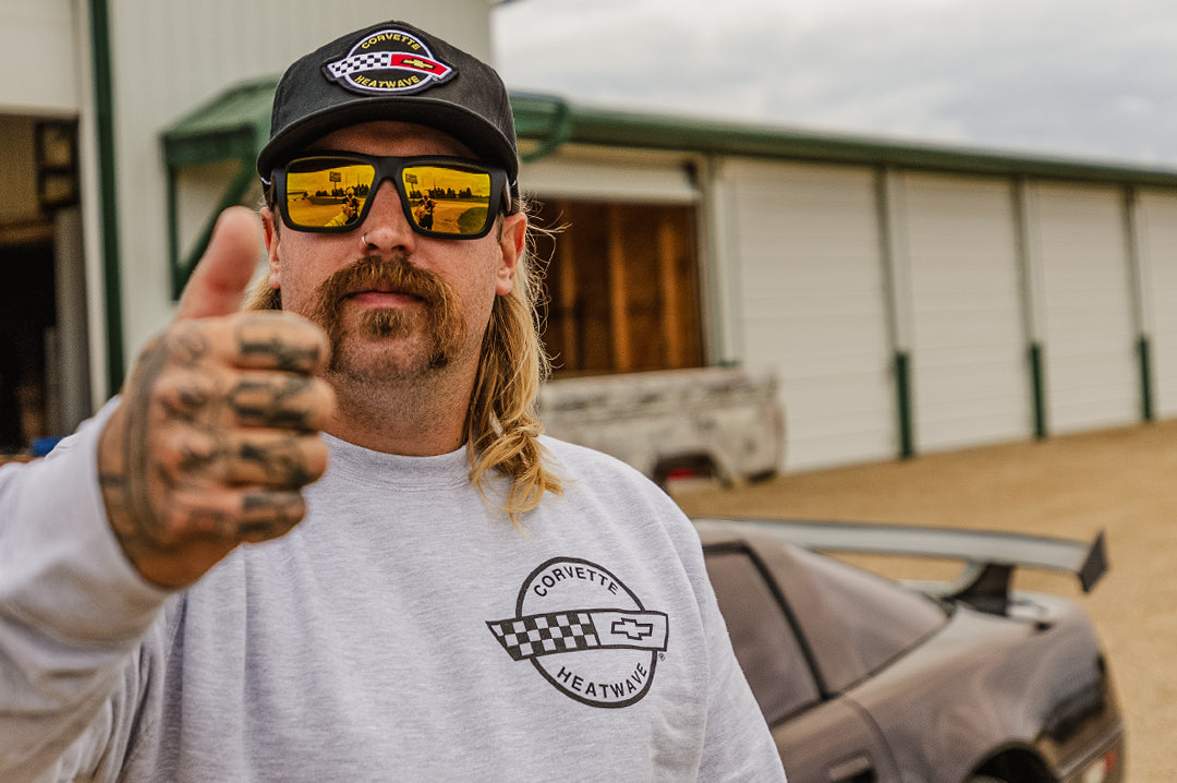 Zack giving a thumbs ups  rocking the Heat Wave Visual XL Vise Sunglasses with black frame, corvette print arms and gold lenses.