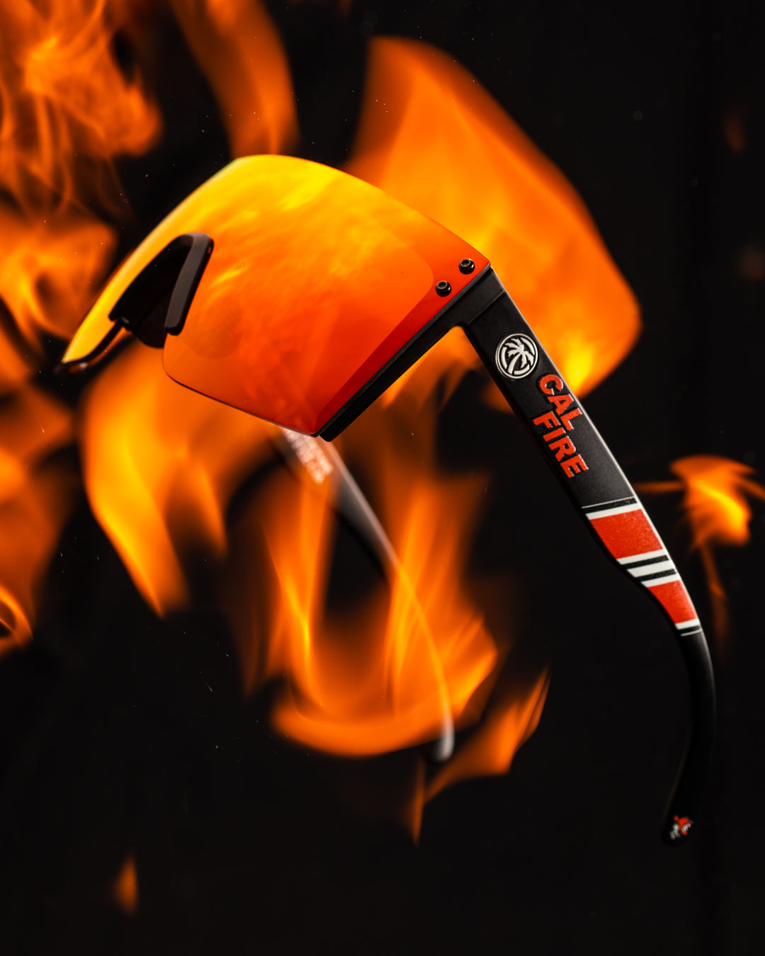 Side view of Heat Wave Visual Lazer Face Z87 Sunglasses with black frame, cal fire print arms and firestorm red lens engulfed in flames. 