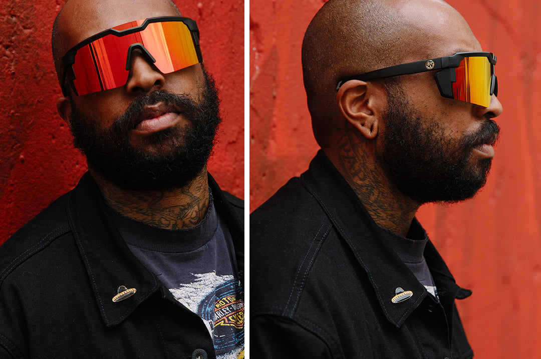 Bearded man wearing Heat Wave Visual Future Tech Sunglasses with black frame and firestorm red lens.