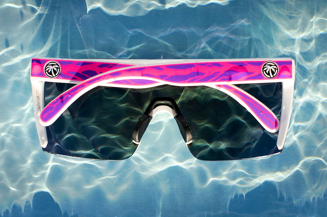 Heat Wave Visual Lazer Face Sunglasses with white frame, jet ski print arms and ultra violet lens lying underwater.