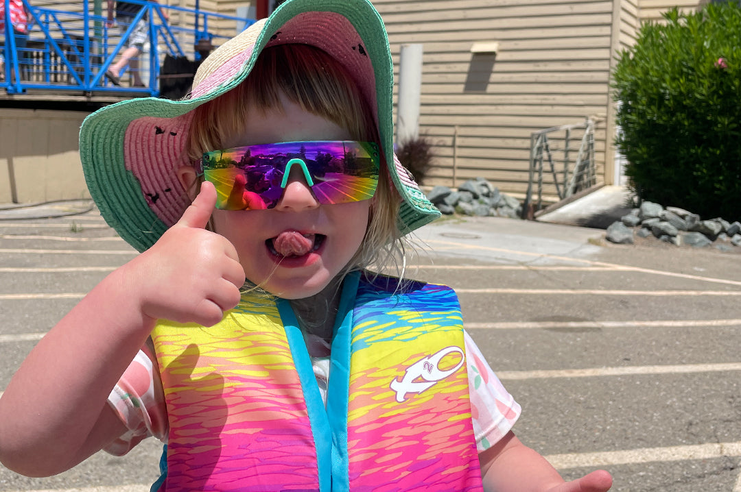 Beach kid wearing Heat Wave Visual Aqua Splash Kids Lazer Face Sunglasses.