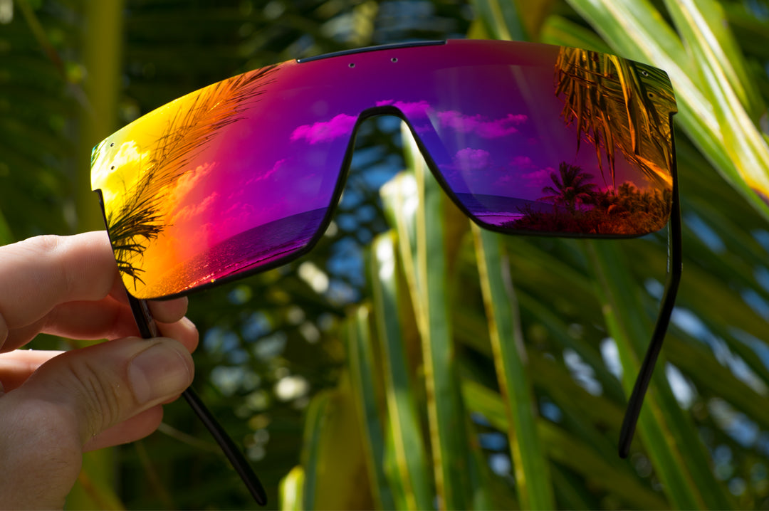 Heat Wave Visual Quatro Sunglasses with black frame and atmosphere red blue lens in Hawaii beach.