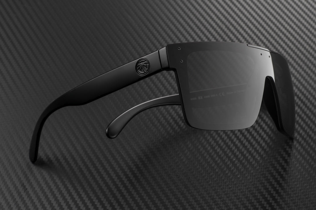 Side view of Heat Wave Visual Quatro Sunglasses with black frame, black bar and black lens on carbon fiber.