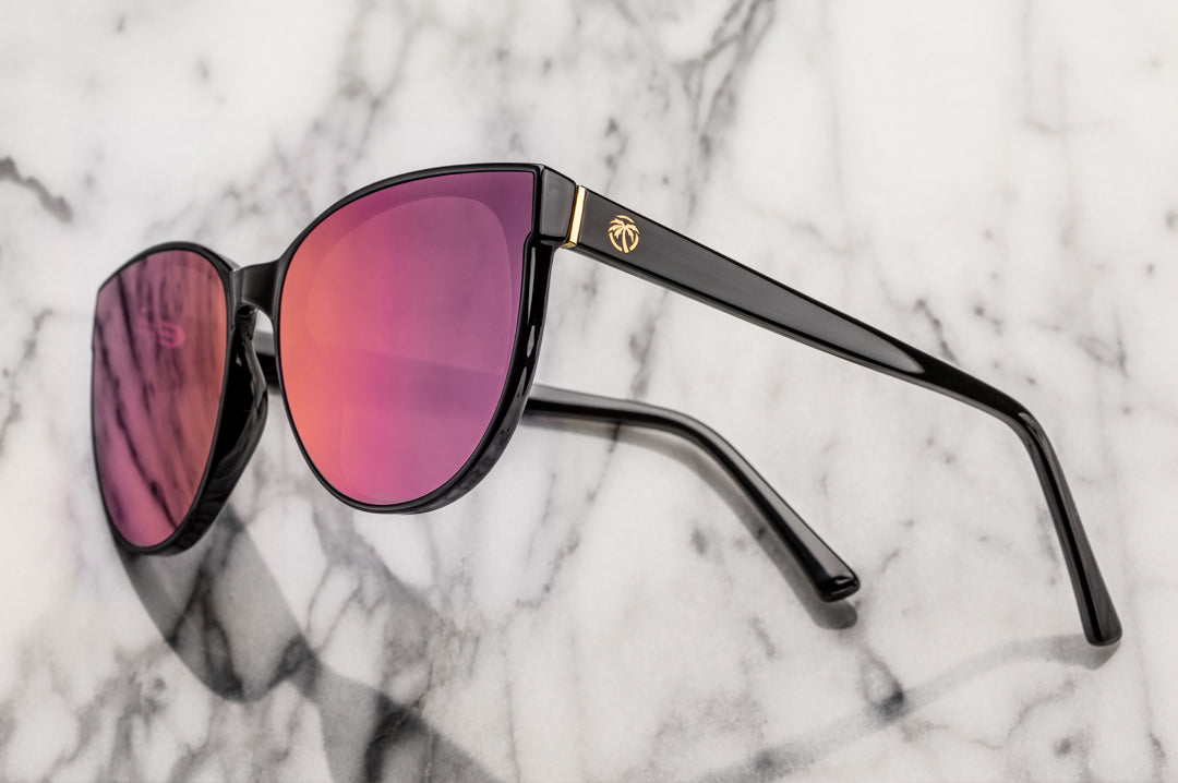 Side view of Heat Wave Visual Womens Carat Sunglasses with black frame and fuchsia lenses.