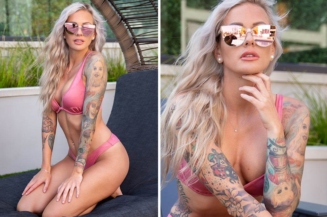 Young woman in swimsuit wearing Heat Wave Visual Womens Carat Sunglasses with clear sparkle frame and rose gold lenses.