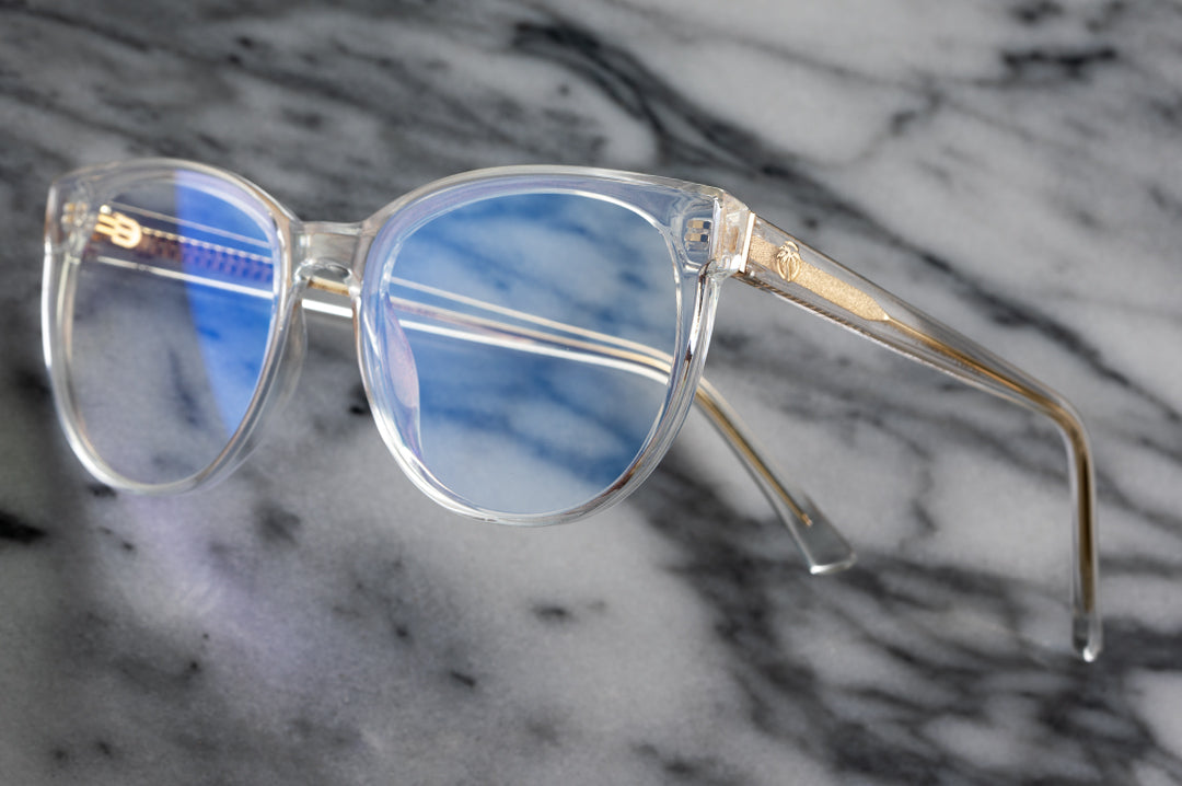 Close up of Heat Wave Visual Womens Carat Sunglasses with clear sparkle frame and clear blue blocker lenses.