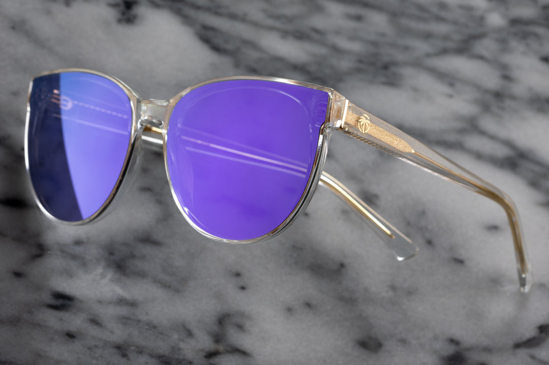 Close up of Heat Wave Visual Womens Carat Sunglasses with clear sparkle frame and ultra violet lenses.