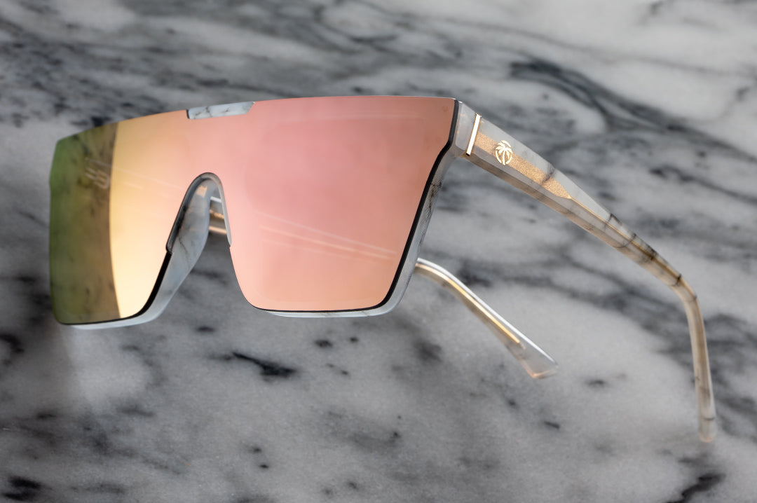 Heat Wave Visual Womens Clarity Sunglasses with marble frame and rose gold lens against marble background.