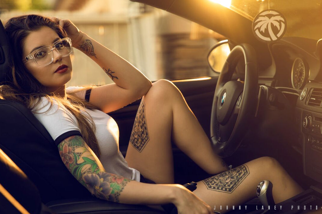 Young women sitting in a car wearing Heat Wave Visual Clear Vise Sunglasses with Clear lenses.