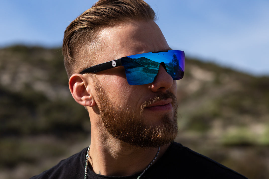 Man out in the desert wearing Heat Wave Visual Quatro Sunglasses with black frame and galaxy blue lens.