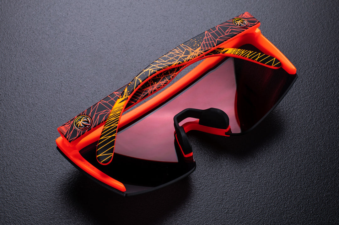 Back view of Heat Wave Visual Lazer Face Z87 Sunglasses with neon red frame, girdwave print arms and firestorm red lens on black table. 