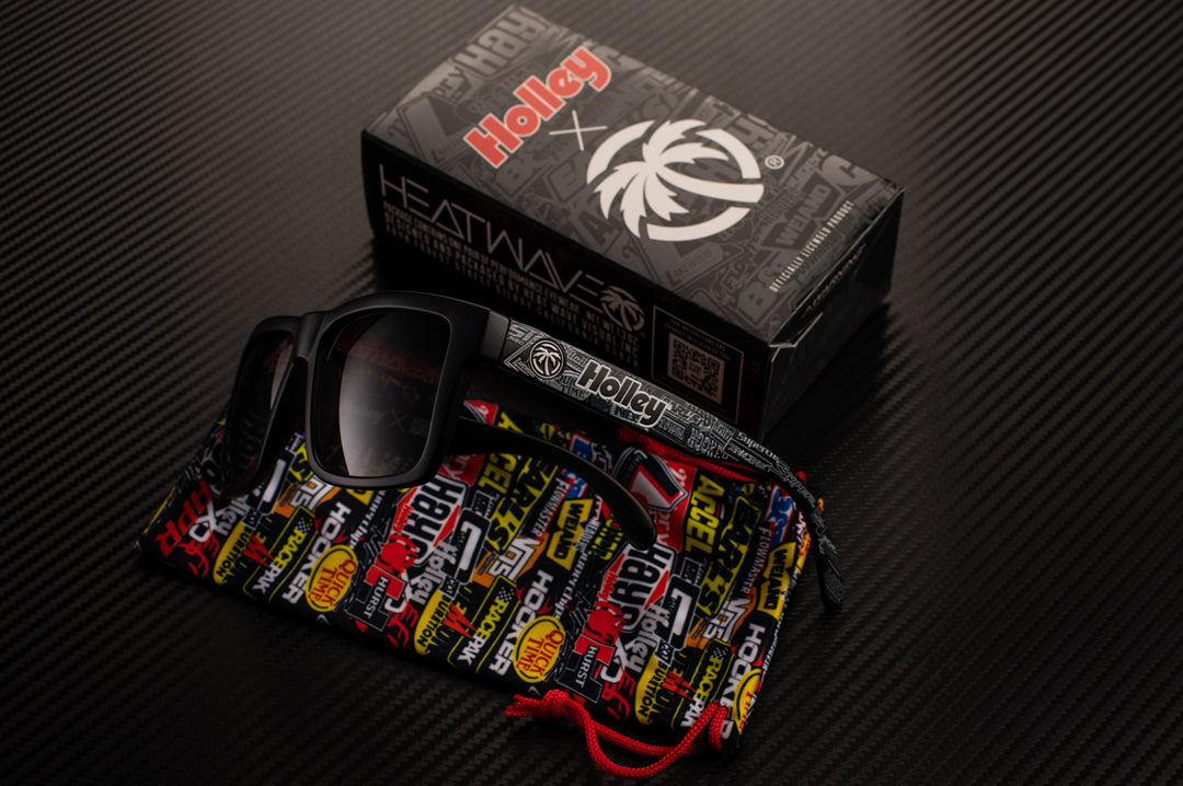 Sitting on it's side is the Heat Wave Visual Vise Sunglasses with black frame, holley print arms and black lens.