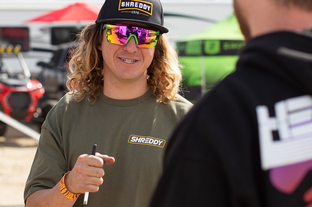Blake Wilkey wearing Heat Wave Visual Lazer Face Z87 Sunglasses with black frame and spectrum pink yellow lens.