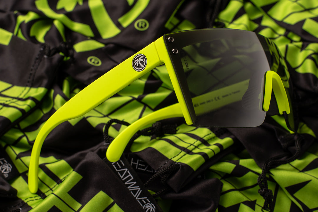 Side view of Heat Wave Visual Lazer Face Z87 Sunglasses with neon yellow frame and black lens on top of microfibers.