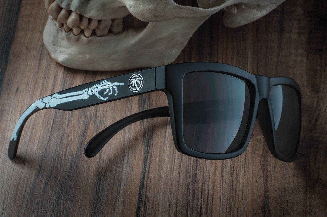 Side view of Heat Wave Visual Vise Sunglasses with black frame, bones print arms and black lenses. 
