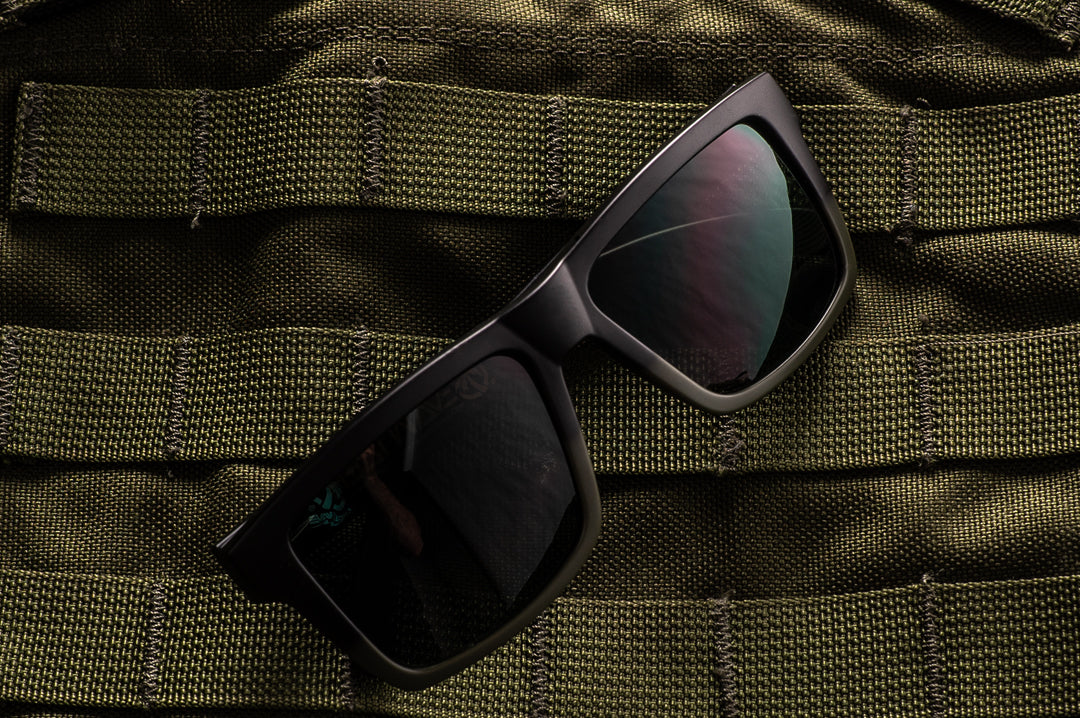 Heat Wave Visual OD green fader Vise sunglasses lying on military vest. 