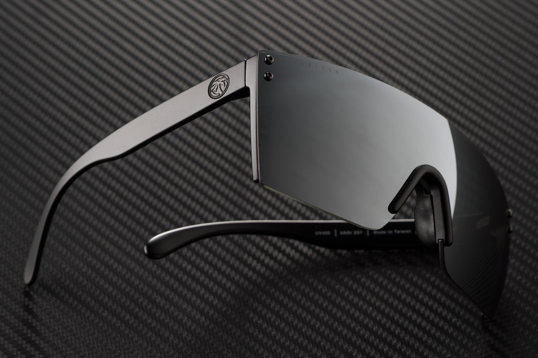 Side view of Heat Wave Visual Lazer Face Z87 Sunglasses with black frame and silver lens on carbon fiber.