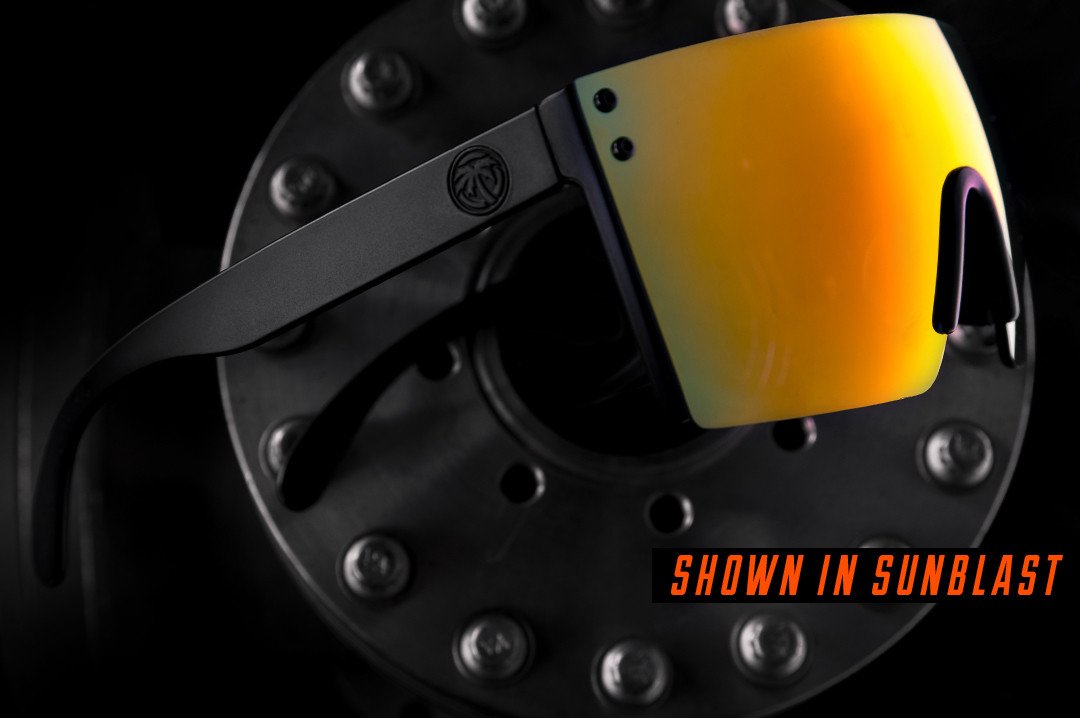 Heat Wave Visual Lazer Face Z87 Sunglasses with black frame and sunblast orange yellow lens lying on a metal pipe.