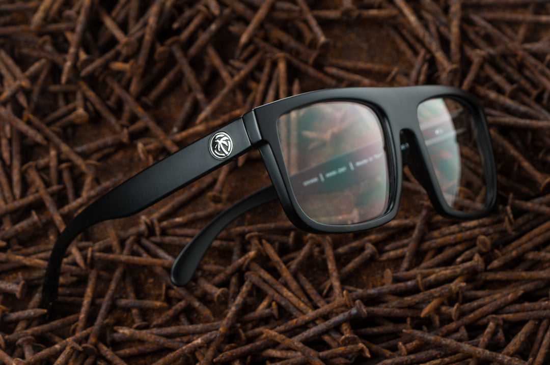 Heat Wave Visual Z87 Regulator Sunglasses with black frame and clear lenses laying in a bed of rusty nails.